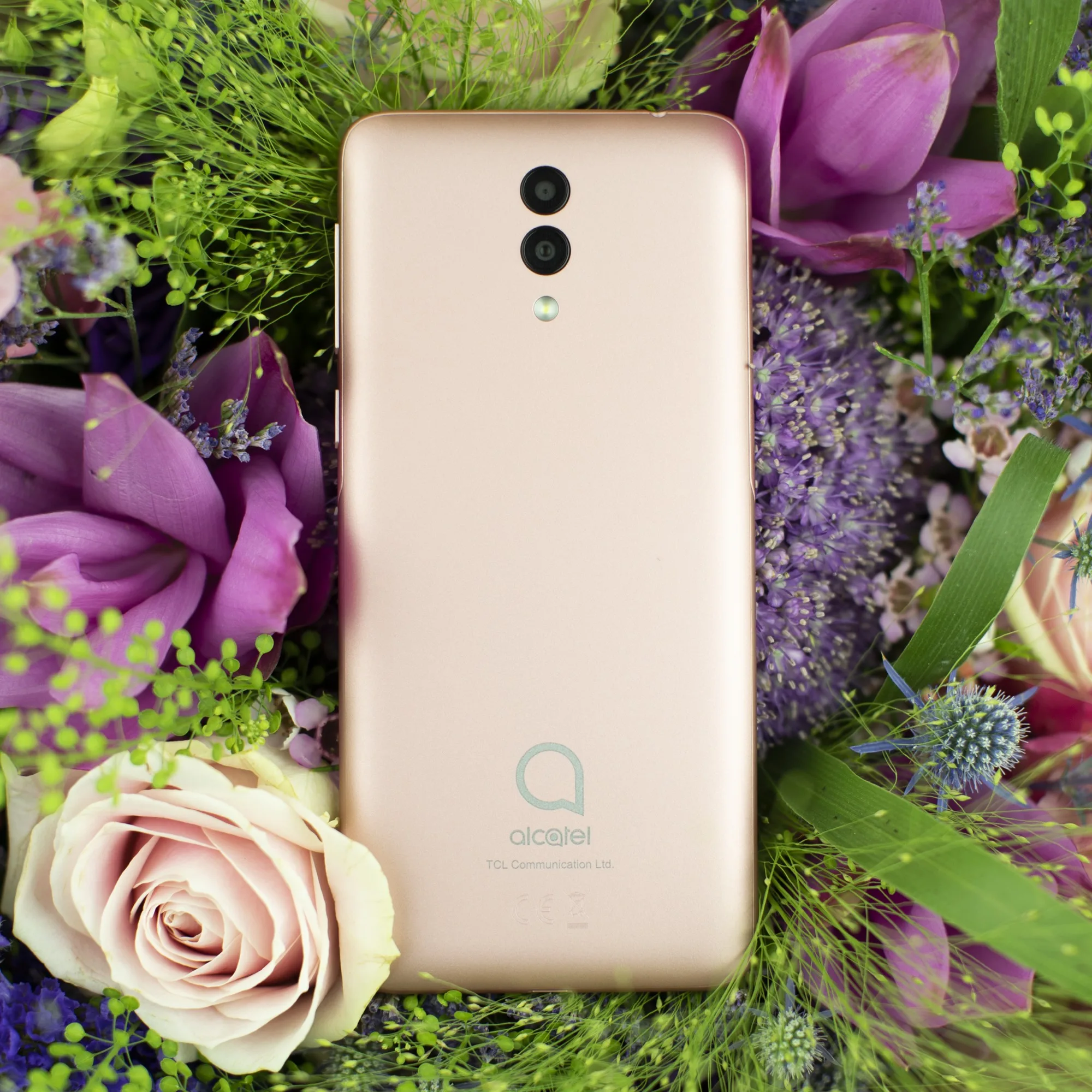 Rose-gold Alcatel 1X nestled in fresh flowers